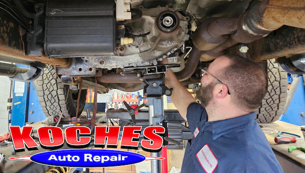 Mechanic working under a car at Koches